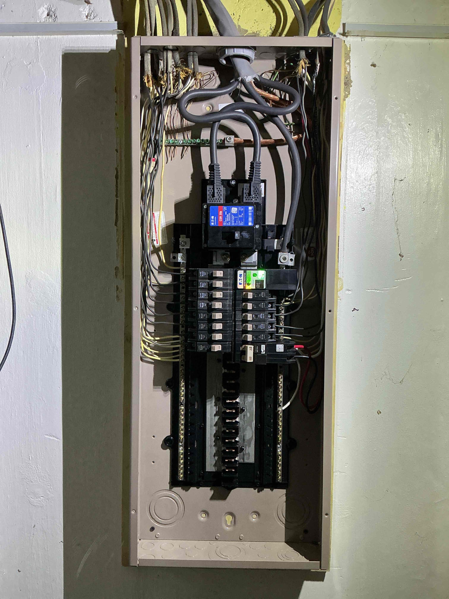See an open electrical panel displaying multiple circuit breakers, connected wires, and a digital monitor at the top—perfect for a Michigan or home electrical upgrade.